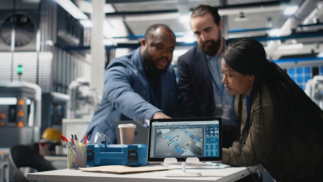 Black engineering specialists reviewing operational workflows in solar power manufacturing plant. Engineers integrating teamwork in alternative energy production line and development. Camera A.