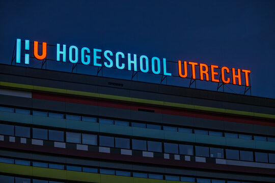 Illuminated neon sign of HU Hogeschool Utrecht university of applied sciences on top of a modern building at dusk or night. Utrecht, Netherlands. 8 March 2026.