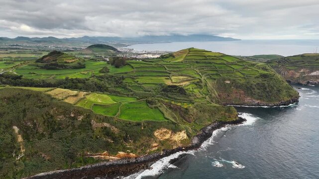 Green rural countryside shaped by volcanic landforms along Atlantic Ocean coast, Sao Miguel, Azores