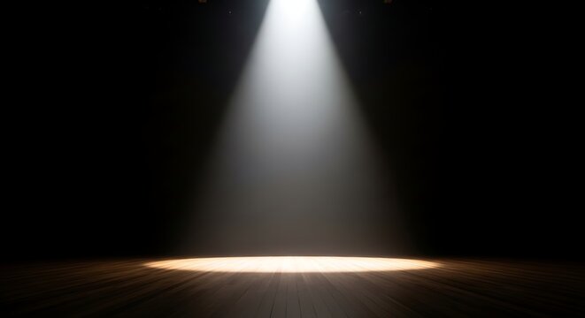 A single dramatic spotlight illuminates an empty wooden stage floor against a completely dark background, creating a theatrical atmosphere.