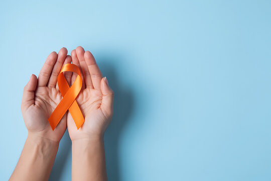 Woman holding orange ribbon on light blue background, top view with space for text. Multiple sclerosis awareness