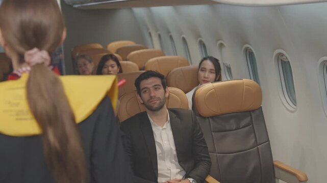 Stewardess Cabin crew, air hostess, Flight attendant demonstrating in uniform safety to passengers inside airplane cabin before departure. aircraft safety. passengers attentively watch instructions.