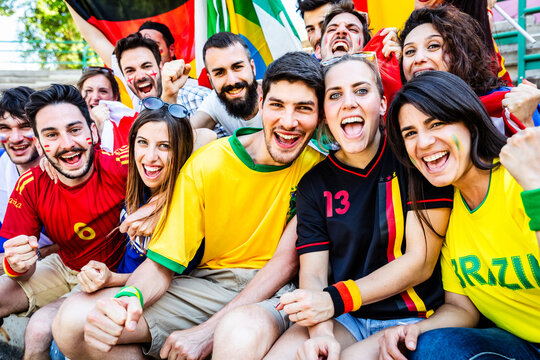 Diverse football fans cheering together at a stadium