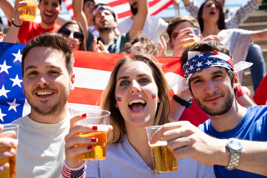 American fans cheering with US flag and beer
