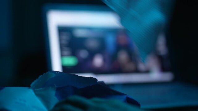 Hand takes out a napkin in front of a laptop at night