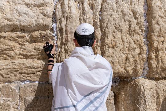 Jewish teenager praying at the Western wall in Jerusalem