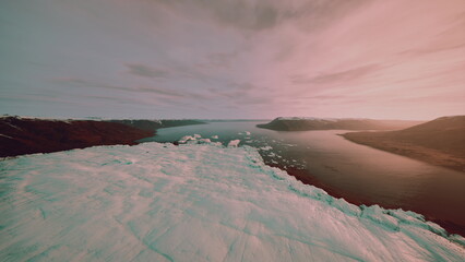 cinematic aerial pastel seascape dusk, filmmaker capturing moody coastline with drifting ice floes, reflective water and dramatic cloudscape, warm pink glow © icetray