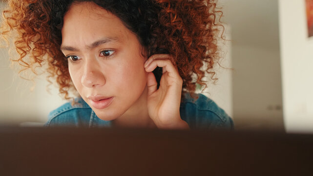 Curious Woman Listening At Home On Laptop
