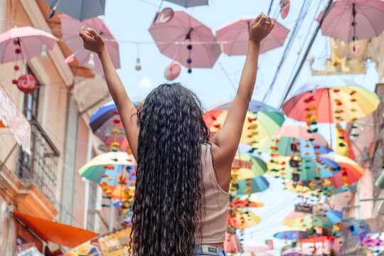 Young Latina woman with her back turned, on vacation on Calle de las Brujas in La Paz, Bolivia - travel concept