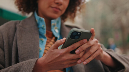 Fototapeta premium Person Using Smartphone Outdoors With Focused Hands