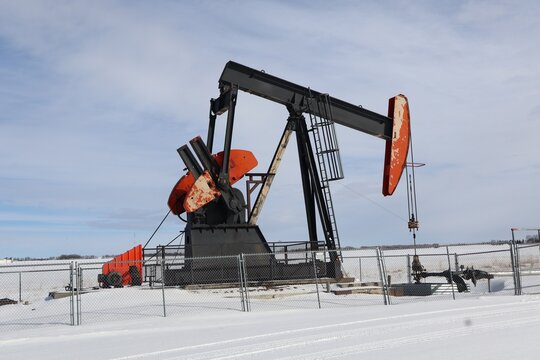 this is an oil pumpjack, a common sight in oil-producing regions like the prairies. These are often colloquially called "nodding donkeys," "horsehead pumps," or "thumping irons". It pumps crude oil.