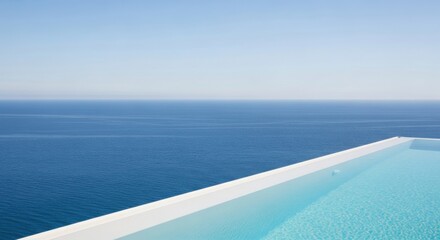 Fototapeta premium Luxurious infinity pool overlooking the vast blue ocean under clear sky