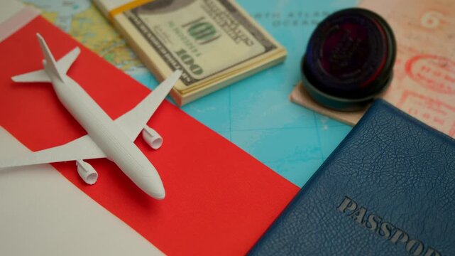 Hand places airplane near passport, Indonesia flag and dollars on map symbolizing international travel and visa process.