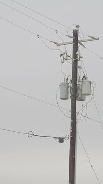 Utility power pole with transformers, insulators, cross-arm, wires/ vertical video