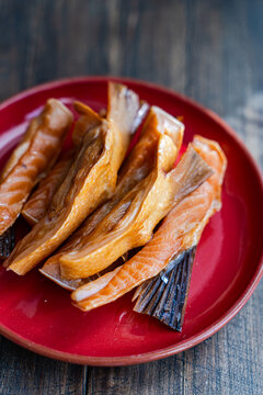 Close-up of a plate of Smoked salmon fillets on a wooden chopping board