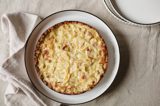Overhead view of a homemade savoury gluten free keto onion and bacon tart on a plate
