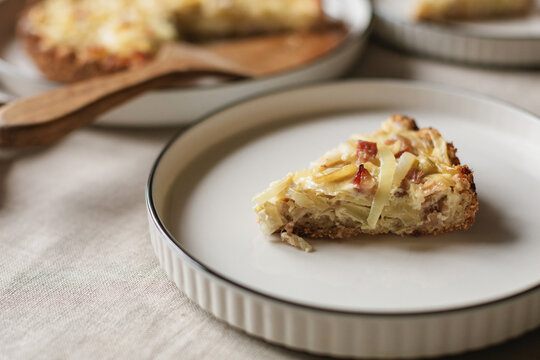 Close-up of a slice of a homemade savoury gluten free keto onion and bacon tart on a plate