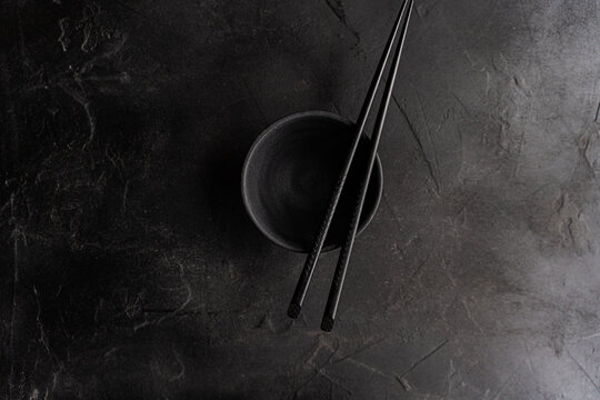 Overhead view of a Chinese tea set with black ceramic cup and chopsticks