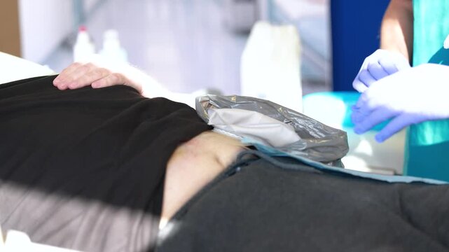 Nurse instructing student in stoma care on patient, ostomy management training in clinical setting