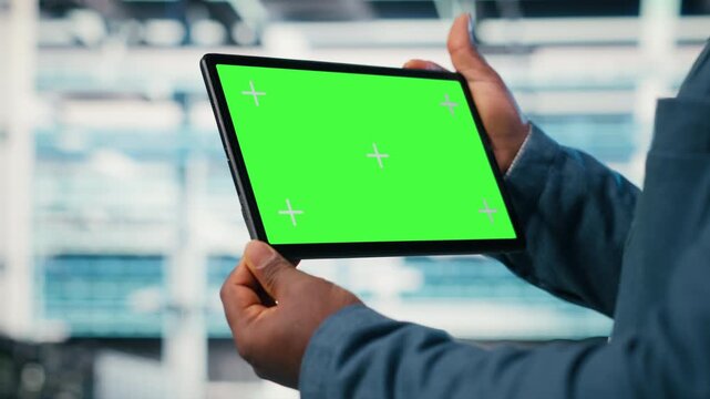 Green screen tablet used by data center worker to manage enterprise cloud computing IT solutions using laptop. Admin using mockup touchscreen device to monitor futuristic server farm, camera B