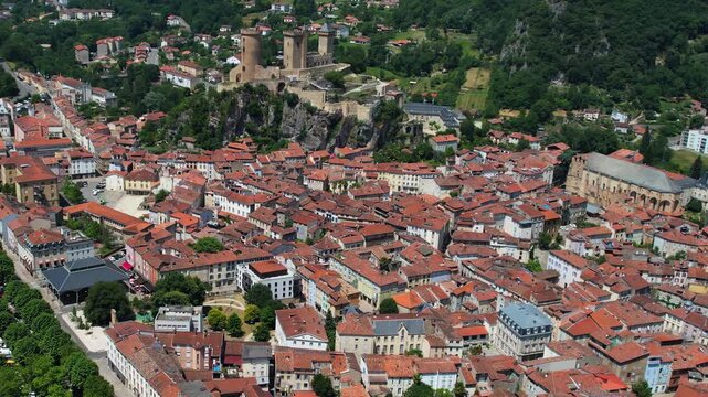 An aerial view around the old town in the city Foix on a sunny summer noon in France .