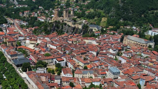 An aerial view around the old town in the city Foix on a sunny summer noon in France .