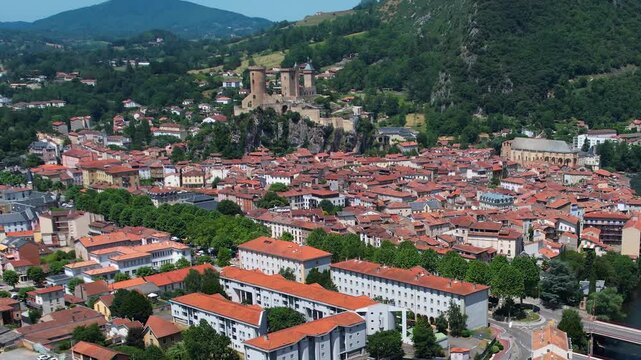 An aerial view around the old town in the city Foix on a sunny summer noon in France .