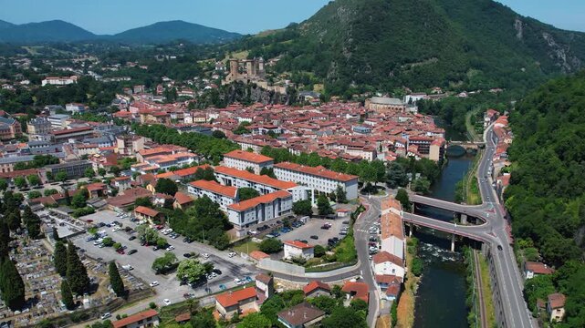 An aerial view around the old town in the city Foix on a sunny summer noon in France .