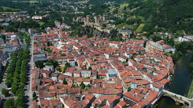 An aerial view around the old town in the city Foix on a sunny summer noon in France .