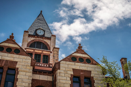 Close Up of Stone and Brick Courthouse Building With Clock Tower  and Cloudy Blue Sky in Stephenville, Texas
