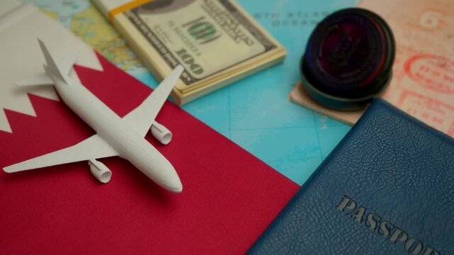 Travel concept with airplane, stamped passport, and dollar notes over world map showing Qatar flag, symbol of Middle East tourism and business travel.