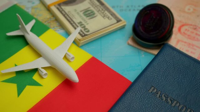 Travel concept with airplane, stamped passport, and dollar notes over world map showing Senegal flag, symbol of West African tourism.