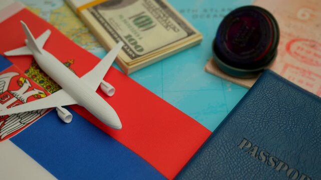 Airplane above world map with Serbia flag, passport with visa and dollar stack representing international travel and trip to Belgrade.