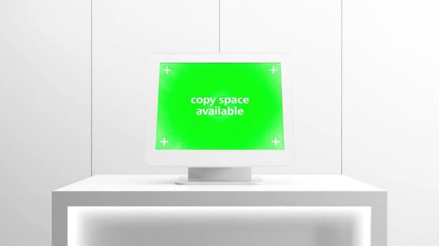 Modern white computer monitor with a green screen for copy space on a minimalist table in a clean room.
