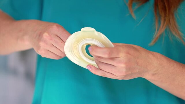 Cutting ostomy wafer opening with scissors to fit stoma size using precise measurement and stoma care technique