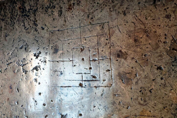 An ancient carved board for playing mills (backgammon) or tabula lusoria variants, on a worn stone surface © JAROSLAW PIWOWARSKI