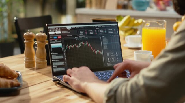 Financial trader at home, day trading fluctuations, monitoring market trends, candlestick charts on laptop used to check platform for investments. Stock exchange assets, crypto currency trade.