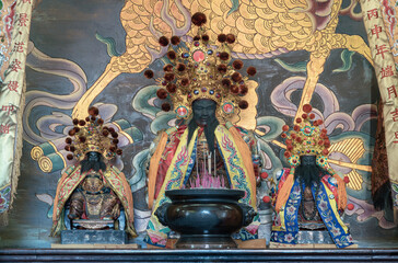 The central altar at Wat Dhammakatanyu enshrines the City God, Jong Jingfu, the patron deity charged with overseeing local spirits. He is flanked by two divine attendants who assist in the spiritual