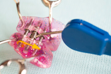Orthodontic plate with screw and tightening keys. A tool for expanding the upper jaw in a child. © dore art
