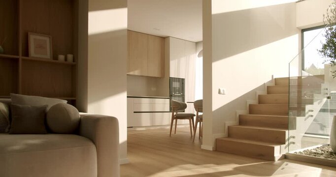 Warm sunlight and shadows moving across the floor and walls of a modern and stylish home interior, showing a living room, kitchen, and wooden staircase in a peaceful time-lapse style