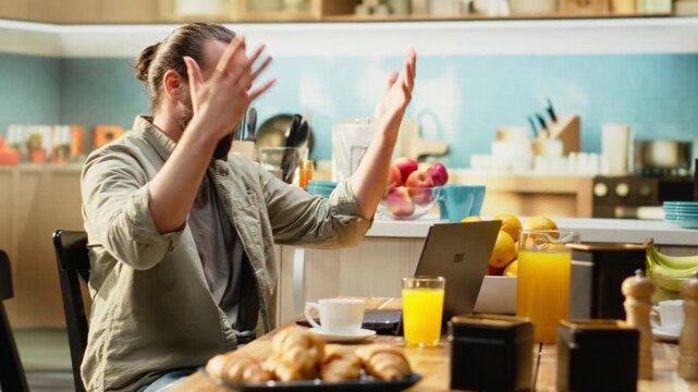 Overwhelmed desperate man receiving bad news during remote work, troubled and worried about difficult times and afraid of career failure. Stressful situation and anxiety at home, teleworking.