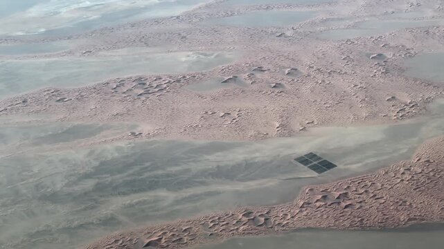 flying across Oman landscape in the Wilayat of Al Sinaina in Al Buraimi Governorate with "Diwan of the Royal Court - Date Palm Trees Farm Alqabil (Al Wajan), " located in the desert between sand dunes