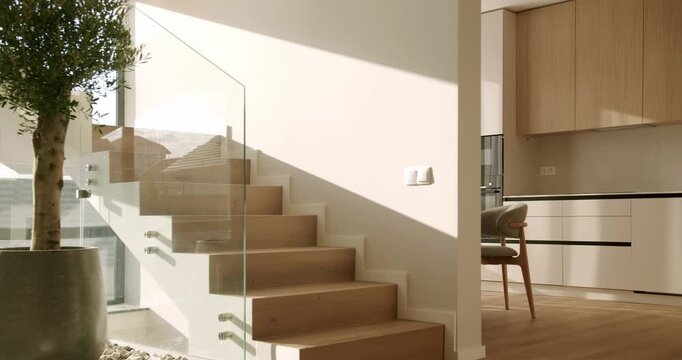 Timelapse of sunlight and shadows moving across a stylish wooden staircase with a glass balustrade in a contemporary minimalist home, showcasing elegant architecture and modern interior design