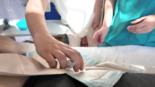 Close view of nursing instructor explaining ostomy bag drainage to student nurse during colostomy care training