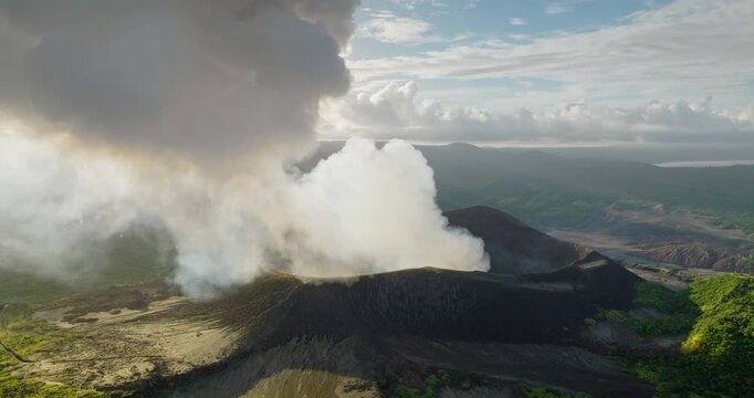 Mount Yasur active volcano erupting, sending a large plume of ash and smoke into the air, revealing its raw power and the dramatic geological processes shaping Vanuatu Tanna Island. Aerial panorama