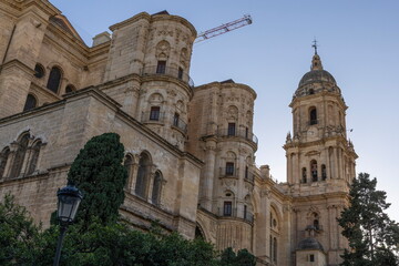Fototapeta premium Historical architecture stands tall in Malaga Spain during the evening light as shadows play on the stone walls and tower