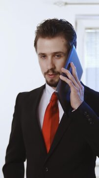 Businessman talk on the big tablet phone looking stupid