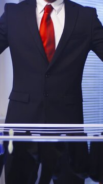 Headless Businessman with red tie doing laundry housework
