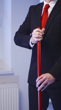 Headless Businessman with red tie clean the floor doing housework