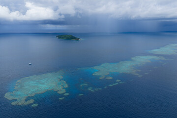 A small ship rests at anchor near a magnificent barrier reef in Fiji's Bligh Channel, east of Viti Levu. This region harbors high marine biodiversity and is a destination for divers and snorkelers. © ead72